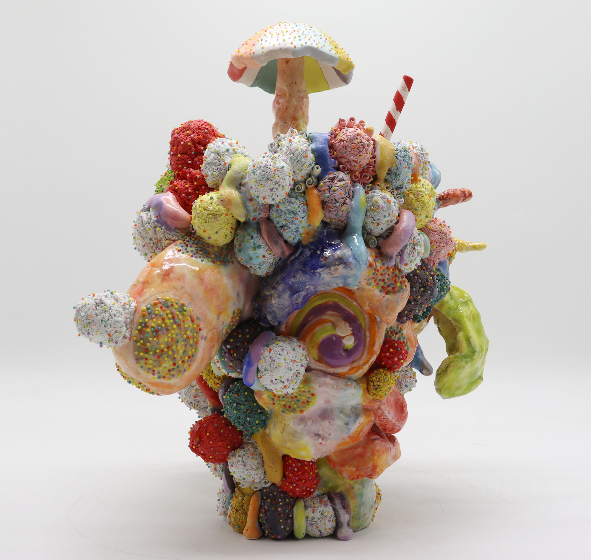 An abstract ceramic sculpture that evokes an ice cream with sprinkles.
