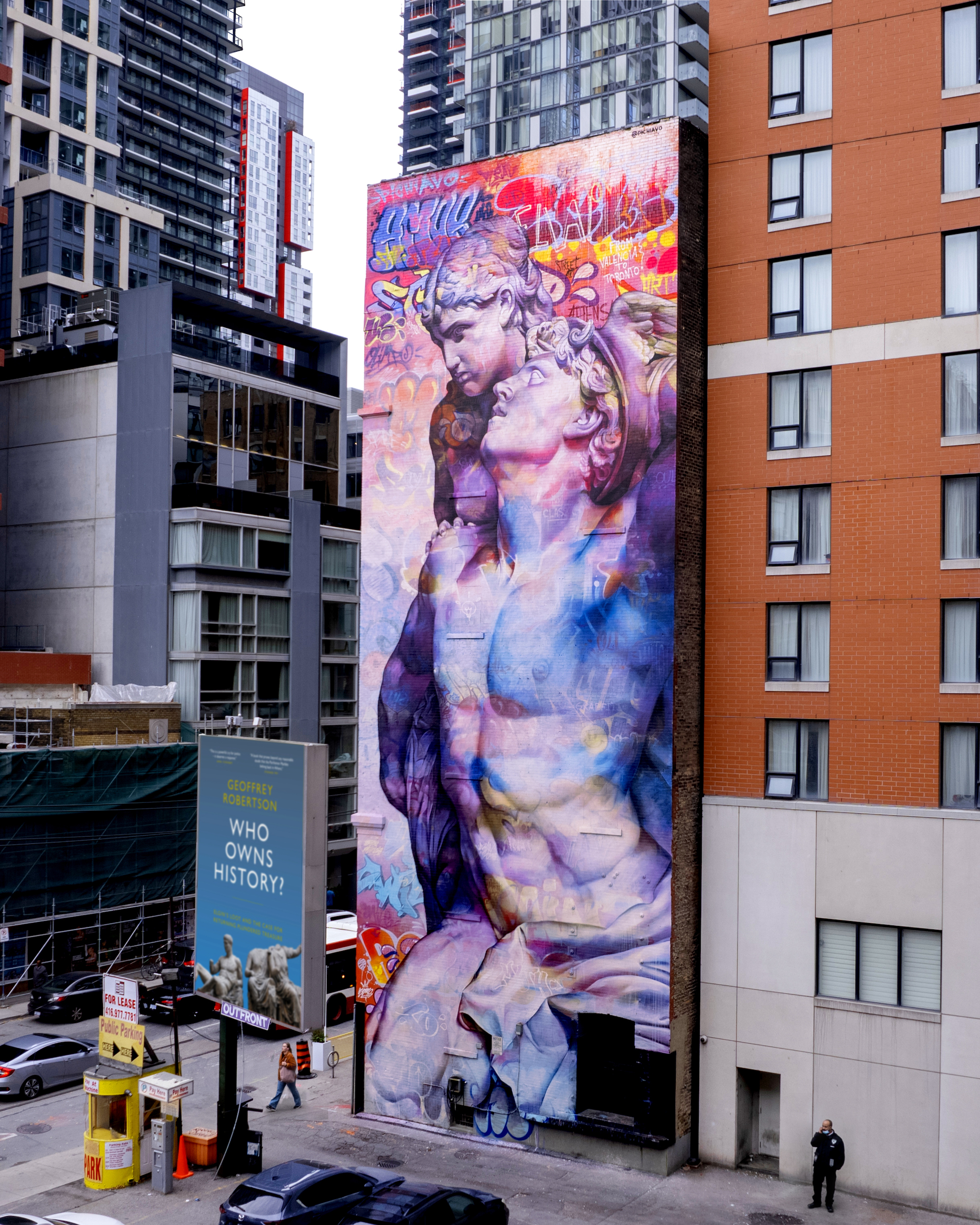 A mural of Mercury and Psyche with graffiti around them on the side of a building.