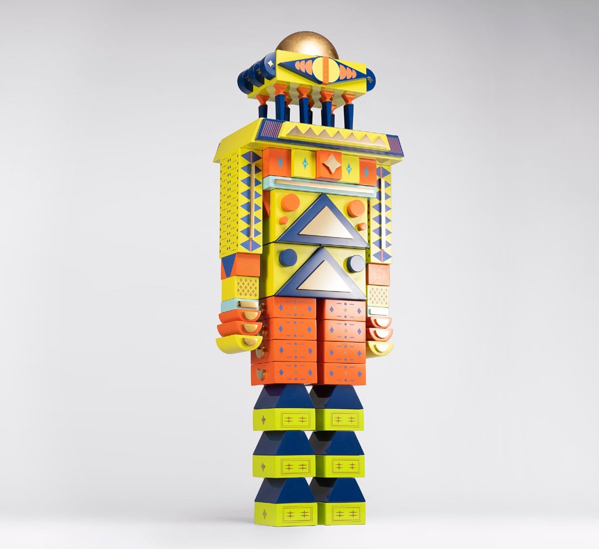 A robot-like character made of geometric blocks in yellow and orange