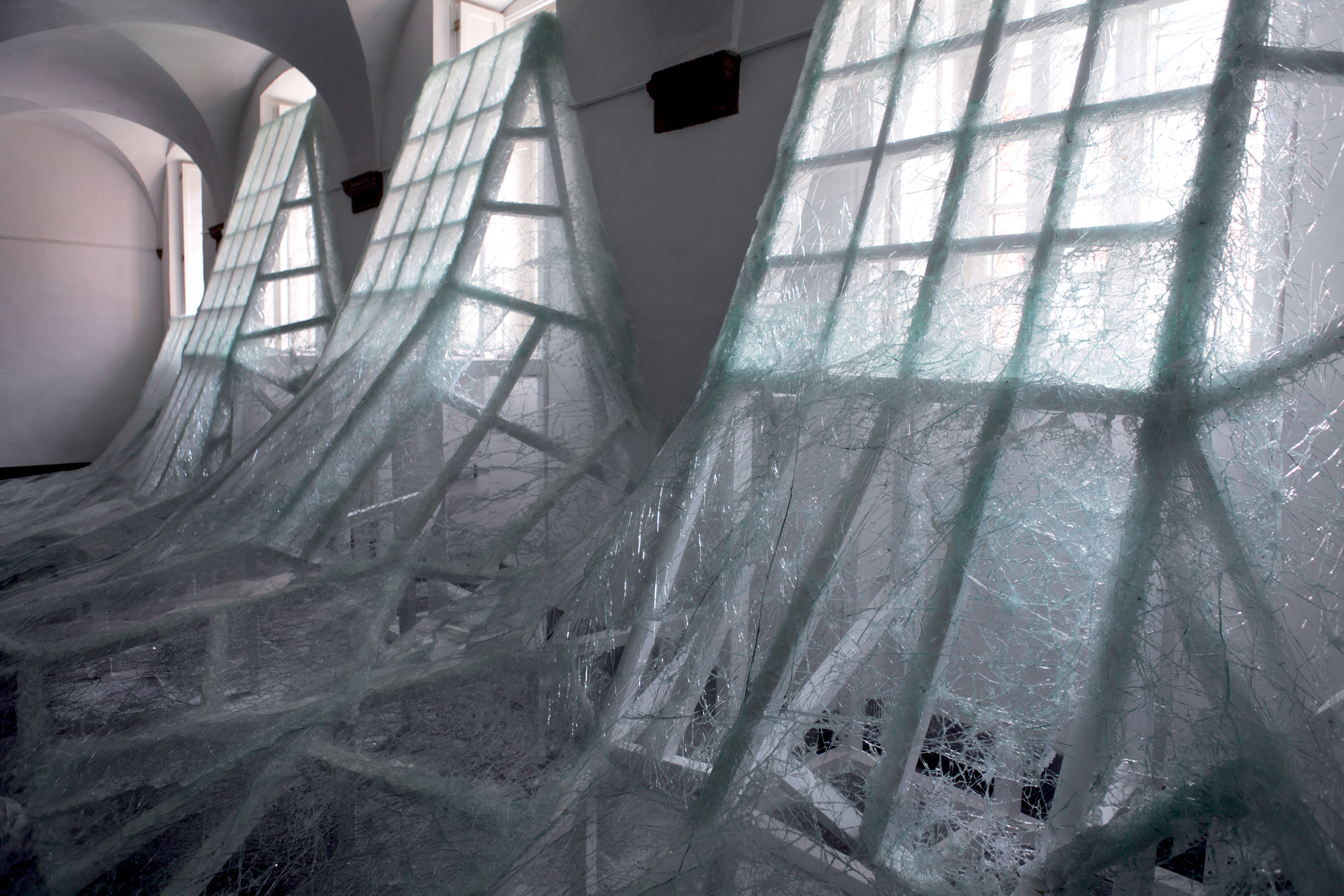 An art installation made of tons of glass that appear to melt off of windows in an old abbey.