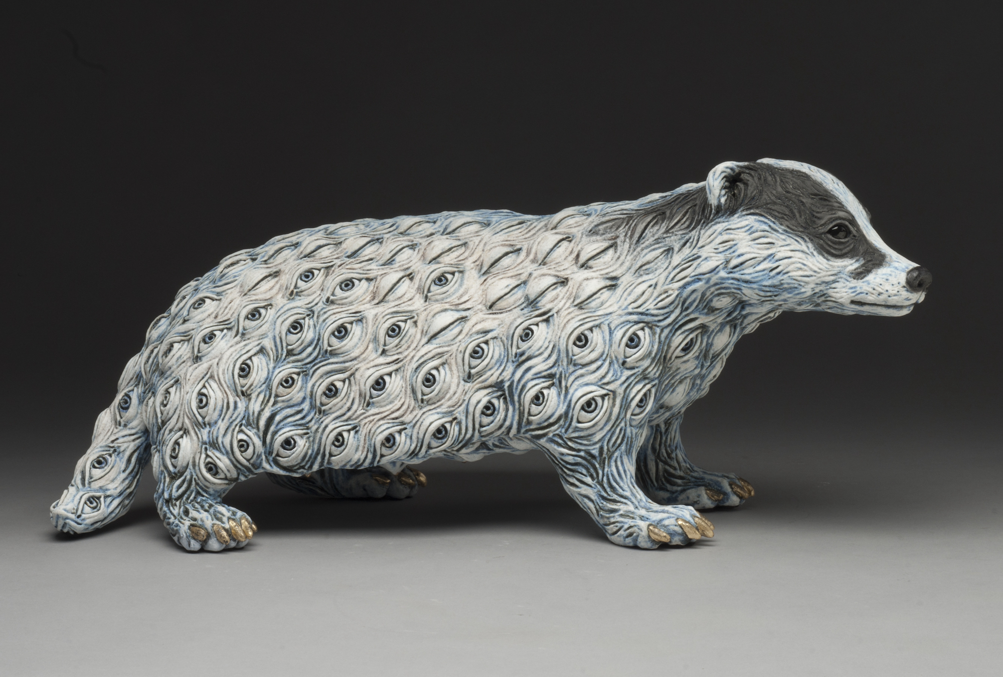 A ceramic sculpture of a badger with fur made of eyes.