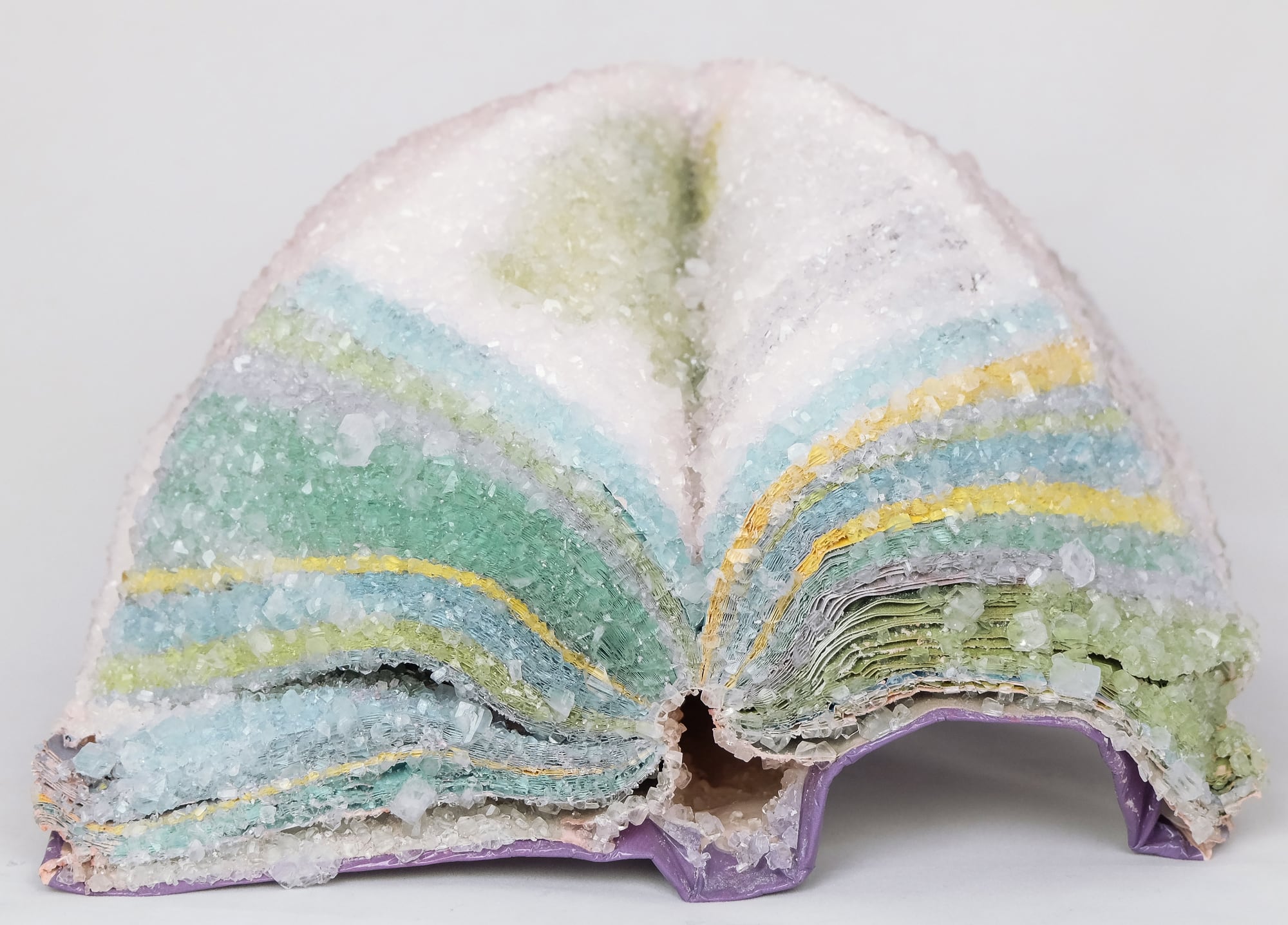 a book with flared colorful pages covered in crystal
