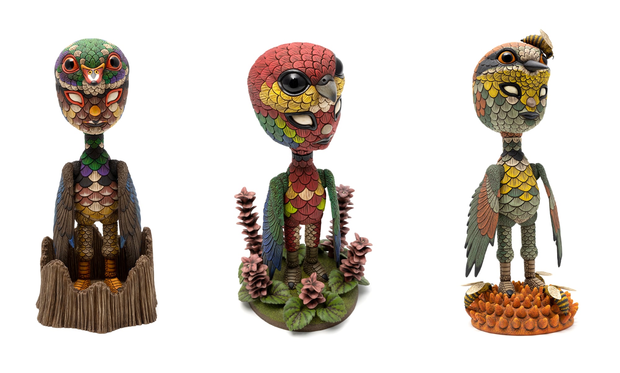 Three ceramic sculptures of a figure camouflaged as birds.