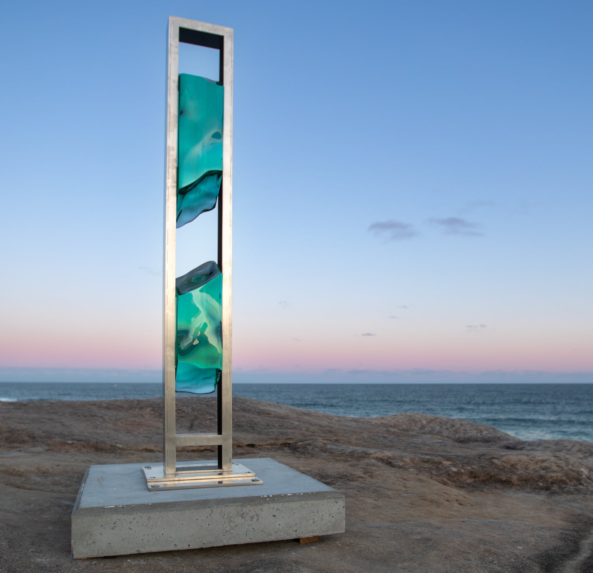 a tall plinth like sculpture with two sections of water-like material