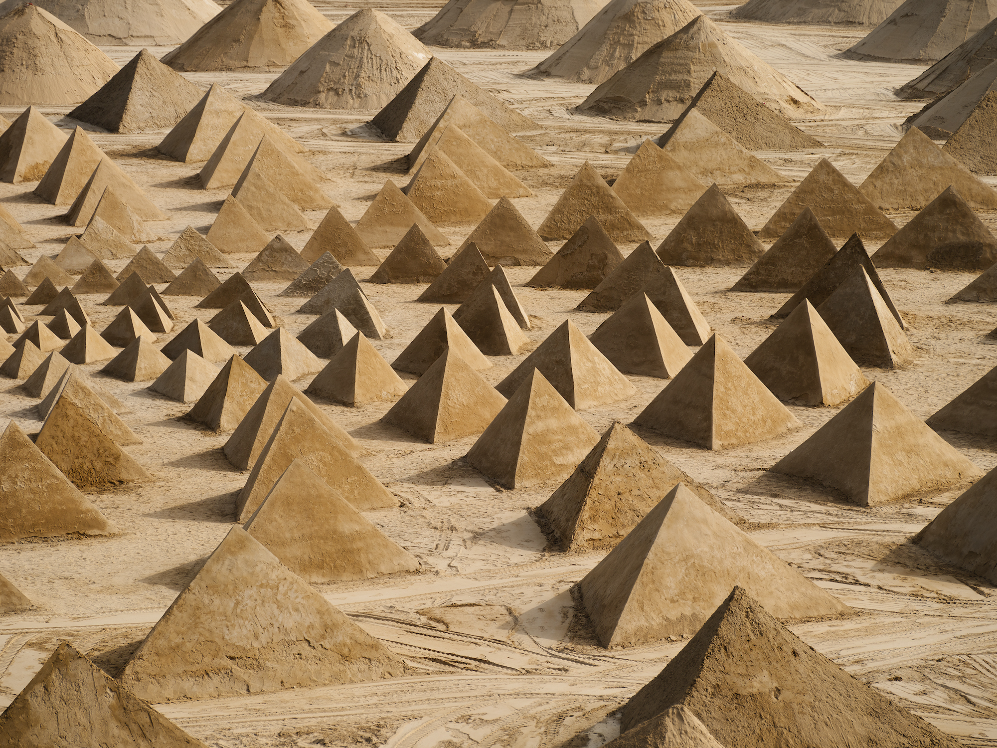 Numerous sand pyramids in a geometric pattern.