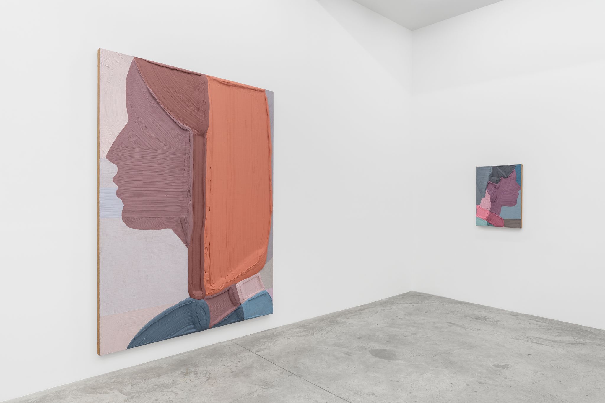 Installation view of two paintings in a white-wall gallery space. The paintings show minimal portraits of female figures in profile.